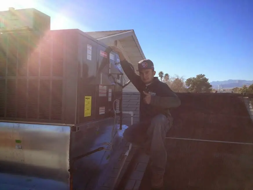HVAC technician performing HVAC Inspection on a rooftop unit in Paradise